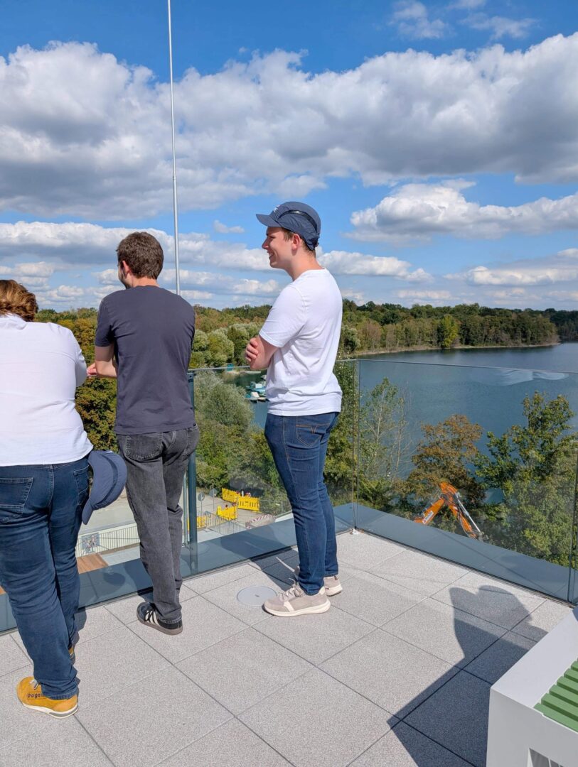 Nils und zwei weitere Personen genießen den Ausblick auf dem See
